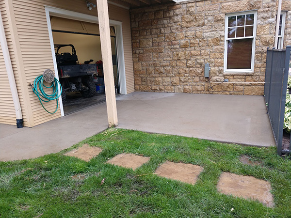 brown home with driveway after pressure wash
