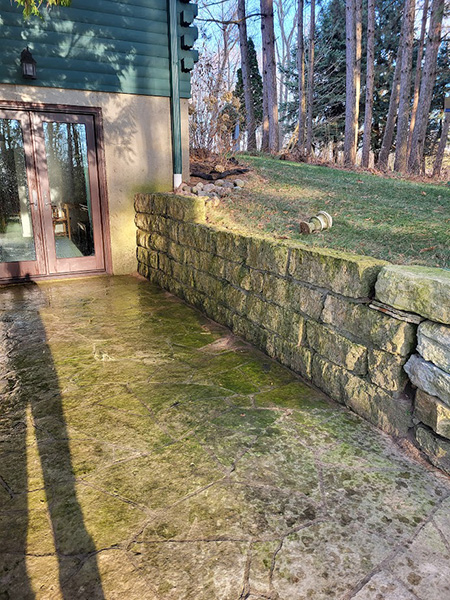 patio and stone wall before pressure wash
