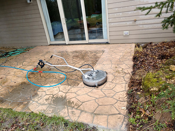 pressure washer on top of patio before and after pressure wash